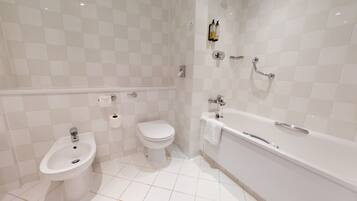 Un bagno moderno con bidet, WC e vasca da bagno.
