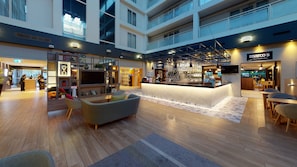 A spacious lobby with a central bar area, seating arrangements, and a reception desk. - Holiday Inn Milton Keynes - Central by IHG (Milton Keynes)