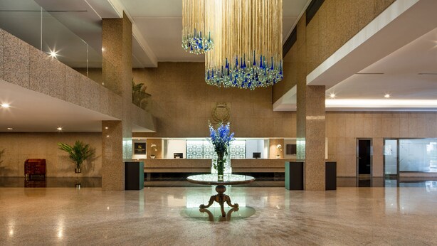 A spacious lobby with a reception desk, a decorative chandelier, and a central plant. - Eurostars Gran Hotel Lugo (Lugo)