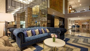 A spacious lobby with a blue sofa, a round coffee table, and a patterned rug. - Eurostars Gran Hotel Lugo (Lugo)