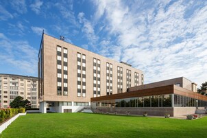 Un edificio moderno con techo plano, ventanas amplias y un espacio al aire libre cubierto.