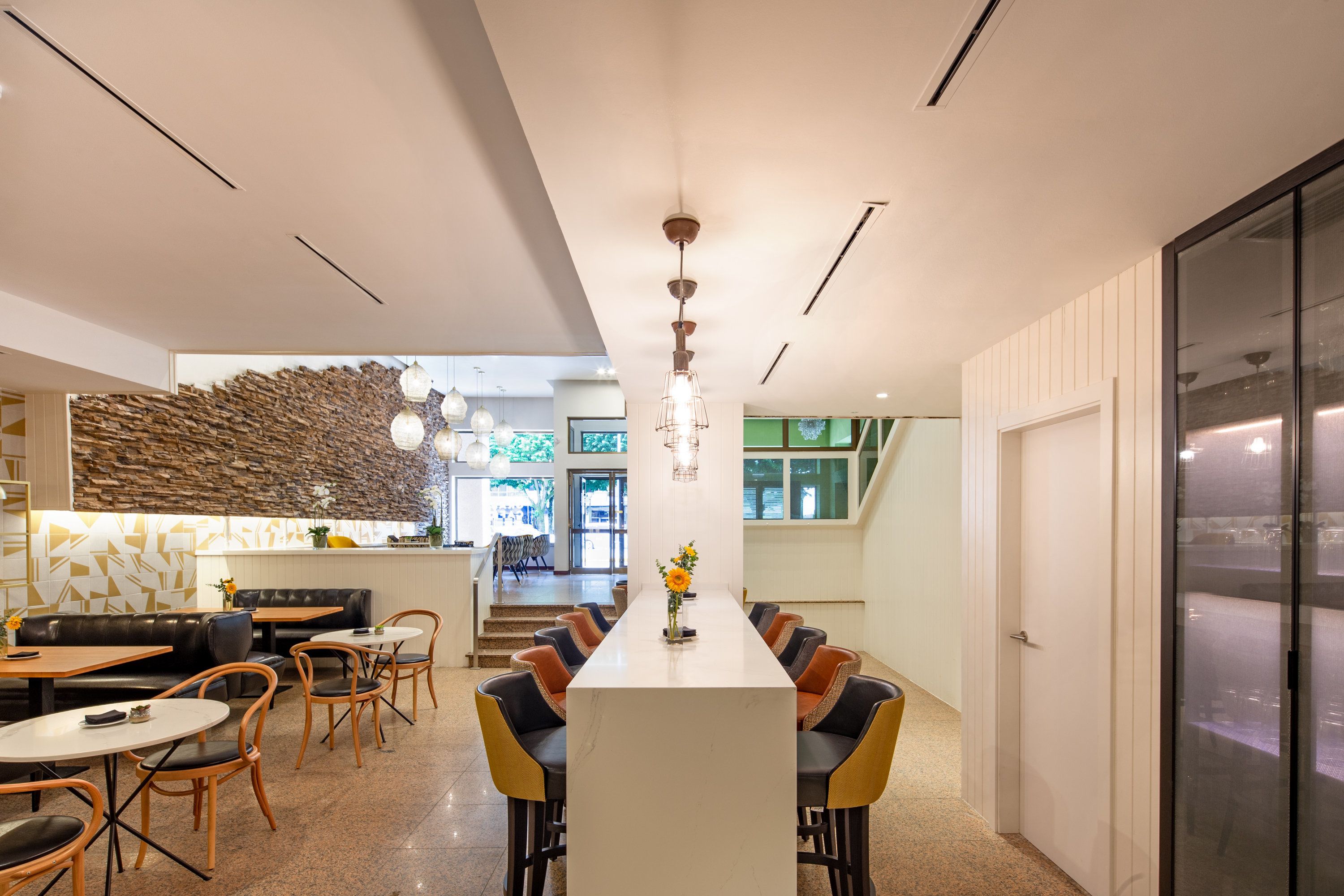 Un comedor moderno con una mesa larga, múltiples sillas y una lámpara central.