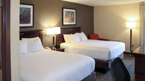 A hotel room with two beds, a desk, a chair, and two lamps. - Mustang Inn (Paducah)