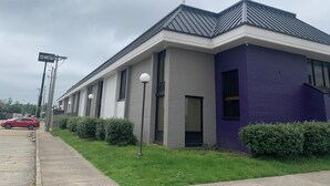 A modern building with a grey and purple facade, large windows, and a flat roof. - Mustang Inn (Paducah)