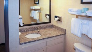 A bathroom with a sink, mirror, and towel rack. - Mustang Inn (Paducah)