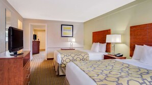 A hotel room with two beds, a TV, a desk, and a chair. - Baymont by Wyndham Jacksonville Orange Park (Jacksonville)