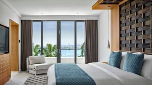A modern hotel room with a large bed, a sofa, a TV, and a balcony with a city view. - Parklane, a Luxury Collection Resort & Spa, Limassol (Limassol)