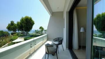 A balcony with two chairs, a table, and a lamp.