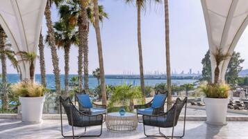 A terrace with two wicker chairs, a small table, and potted plants.