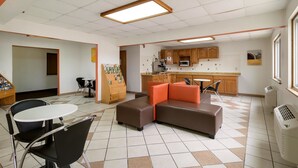 Un espacio habitable compacto con kitchenette, un comedor con mesa y sillas, y una sala de estar con sofá.