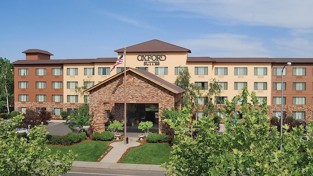 A hotel with a stone facade, multiple floors, and a flag.
