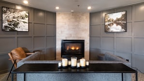 A modern living room with a fireplace, grey walls, and two framed pictures.