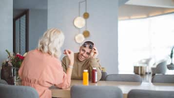 Two people sitting at a table in a modern cafe with a minimalist design, featuring a neutral color palette and contemporary decor.