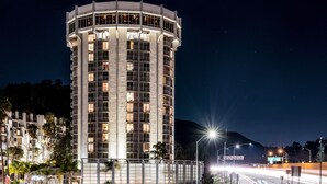 A tall, cylindrical hotel with multiple balconies and a modern design. - Hotel Angeleno (Los Angeles)