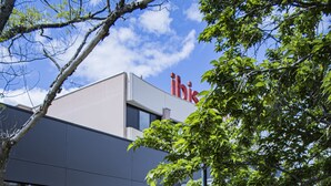 Moderni rakennus, jonka julkisivussa on nimi »ibis», ulkona on metallituoleja ja -pöytiä, ja hyvin hoidettu nurmialue, jossa on myös puita.