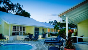 A pool area with lounge chairs and a covered patio.
