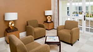 A room with two armchairs, a small table, and two lamps.