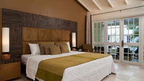 A bedroom with a large bed, a wooden headboard, two bedside tables, and a view through a glass door.