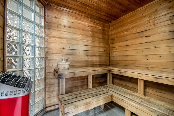 A sauna with wooden benches and a glass door with animal designs.