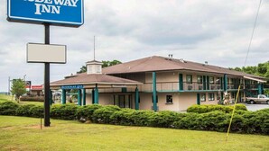 A Rodeway Inn building with a sign, a parking lot, and a clear sky. - Rodeway Inn Phenix City - Columbus (Phenix City)