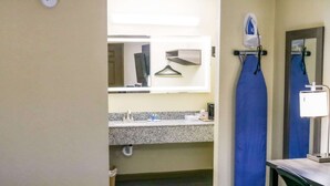 A bathroom with a sink, mirror, and ironing station. - Rodeway Inn Phenix City - Columbus (Phenix City)