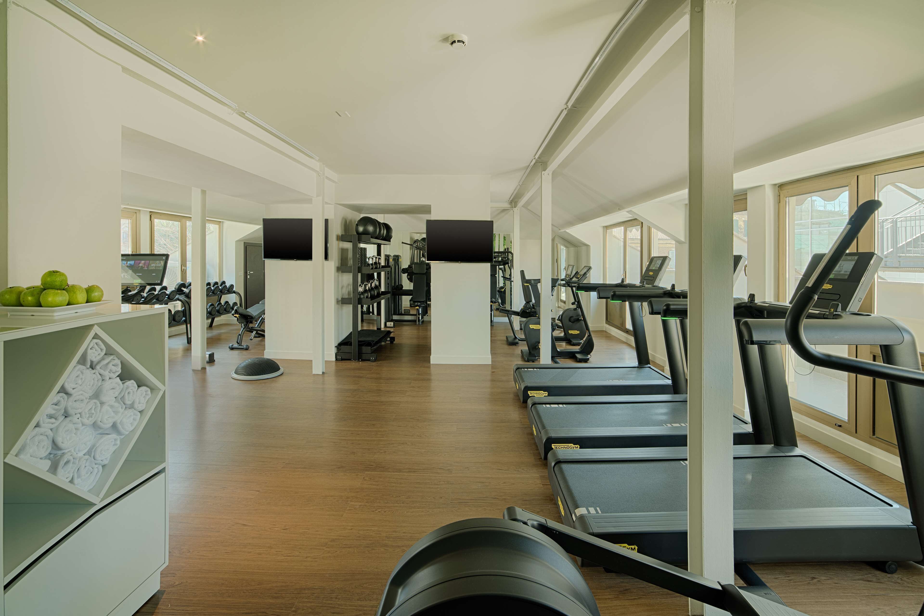 A gym with treadmills, weights, and cardio equipment.