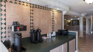 A szálloda recepciója, ahol található egy kávéfőző, két szemeteskosár és egy mikrohullámú sütő a pulton.