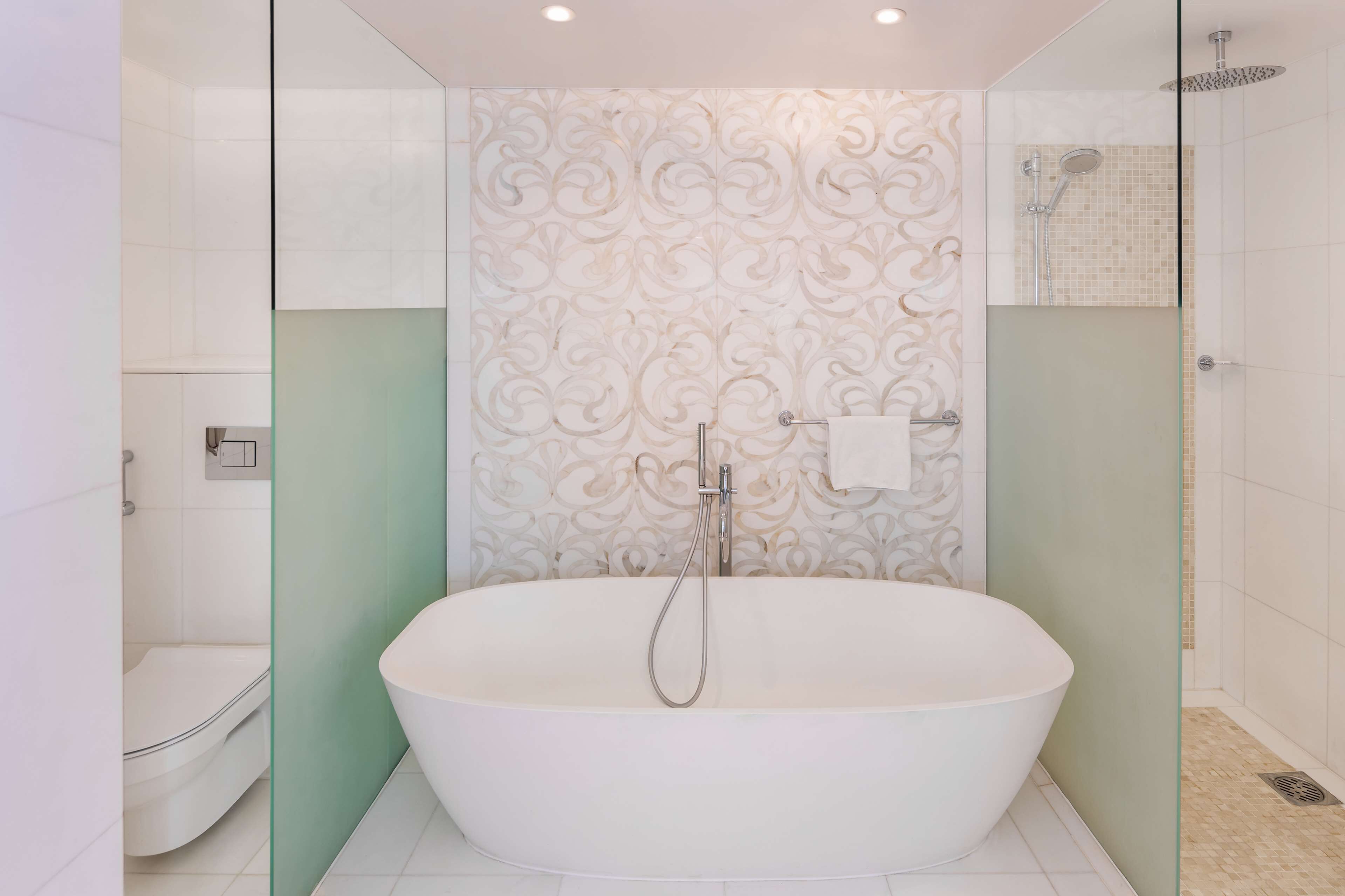 Une salle de bain moderne avec une baignoire sur pieds, une douche à parois de verre et des toilettes.