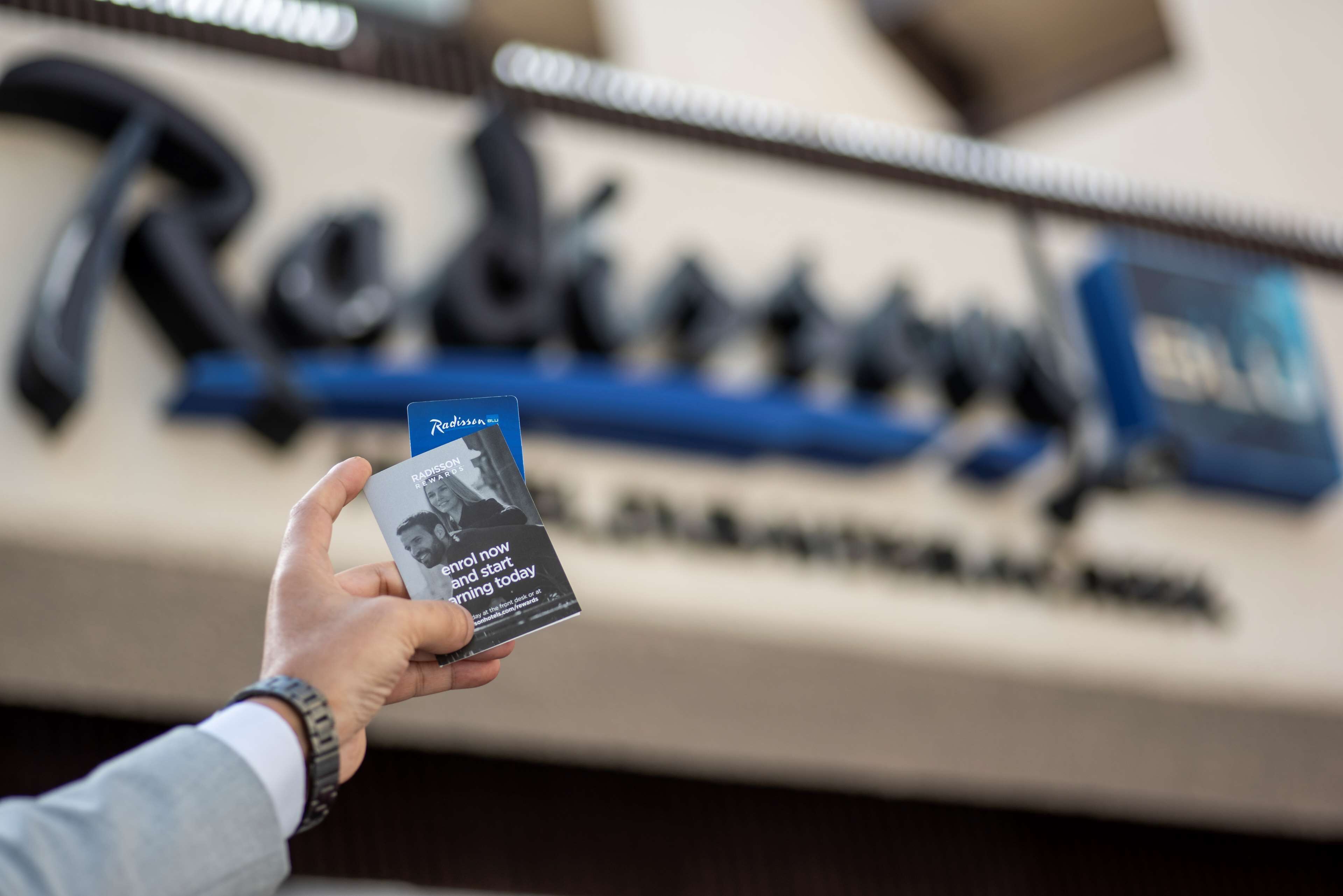 A hand holding a book titled "Rapid Now and Start Learning Today" in front of a blurred background with the word "Reinhold" visible.