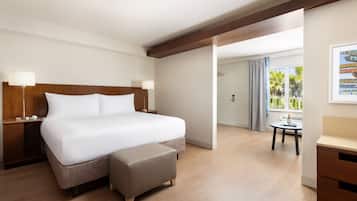 A hotel room with a large bed, a small table, and a desk.