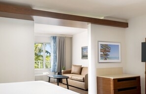 A hotel room with a bed, a small table, a sofa, and a TV.