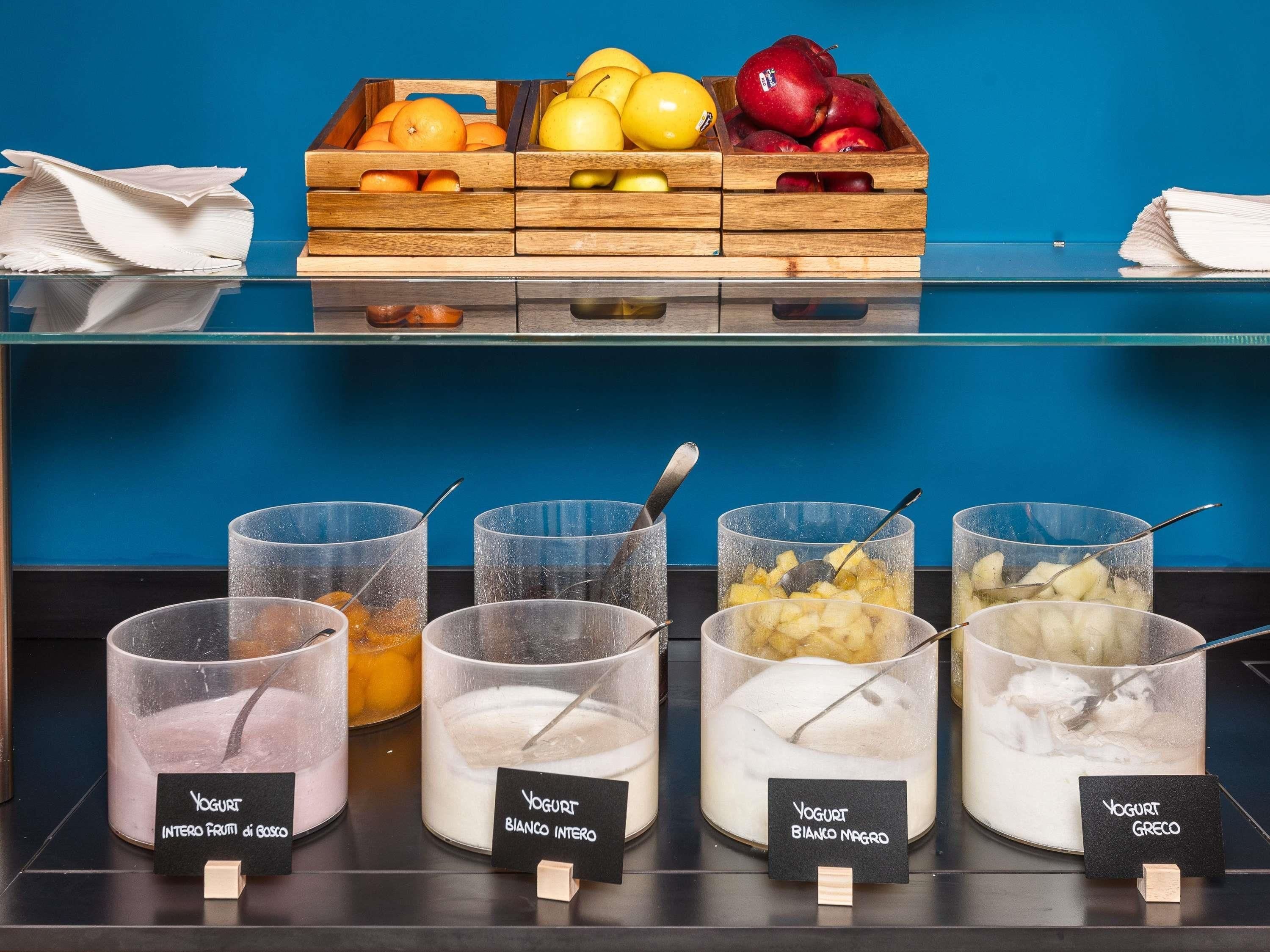 A buffet with various fruit options and labeled yogurt containers.