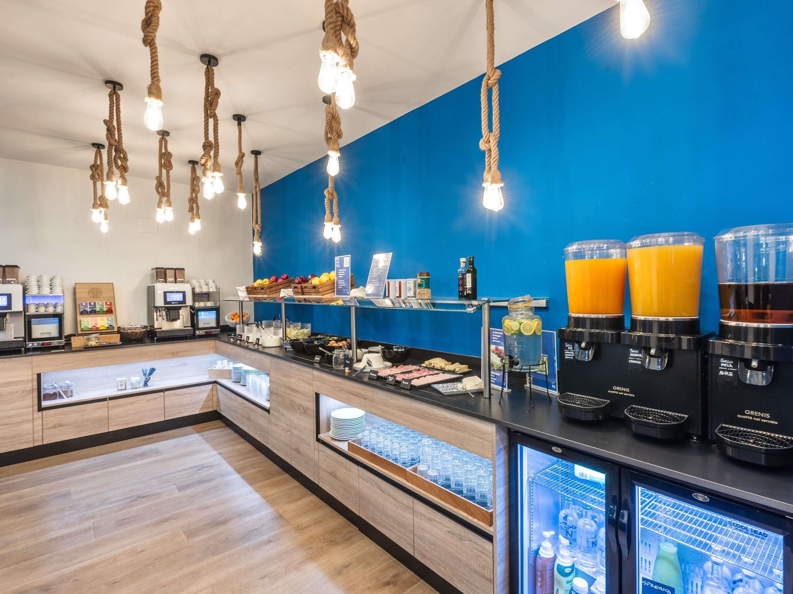 Un espace dédié au petit-déjeuner, équipé d'une machine à café, de distributeurs de jus de fruits et d'un présentoir réfrigéré.