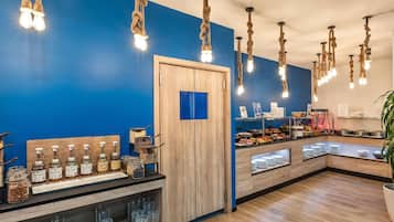 A modern breakfast area with wooden counters, hanging rope lights, and a blue wall.