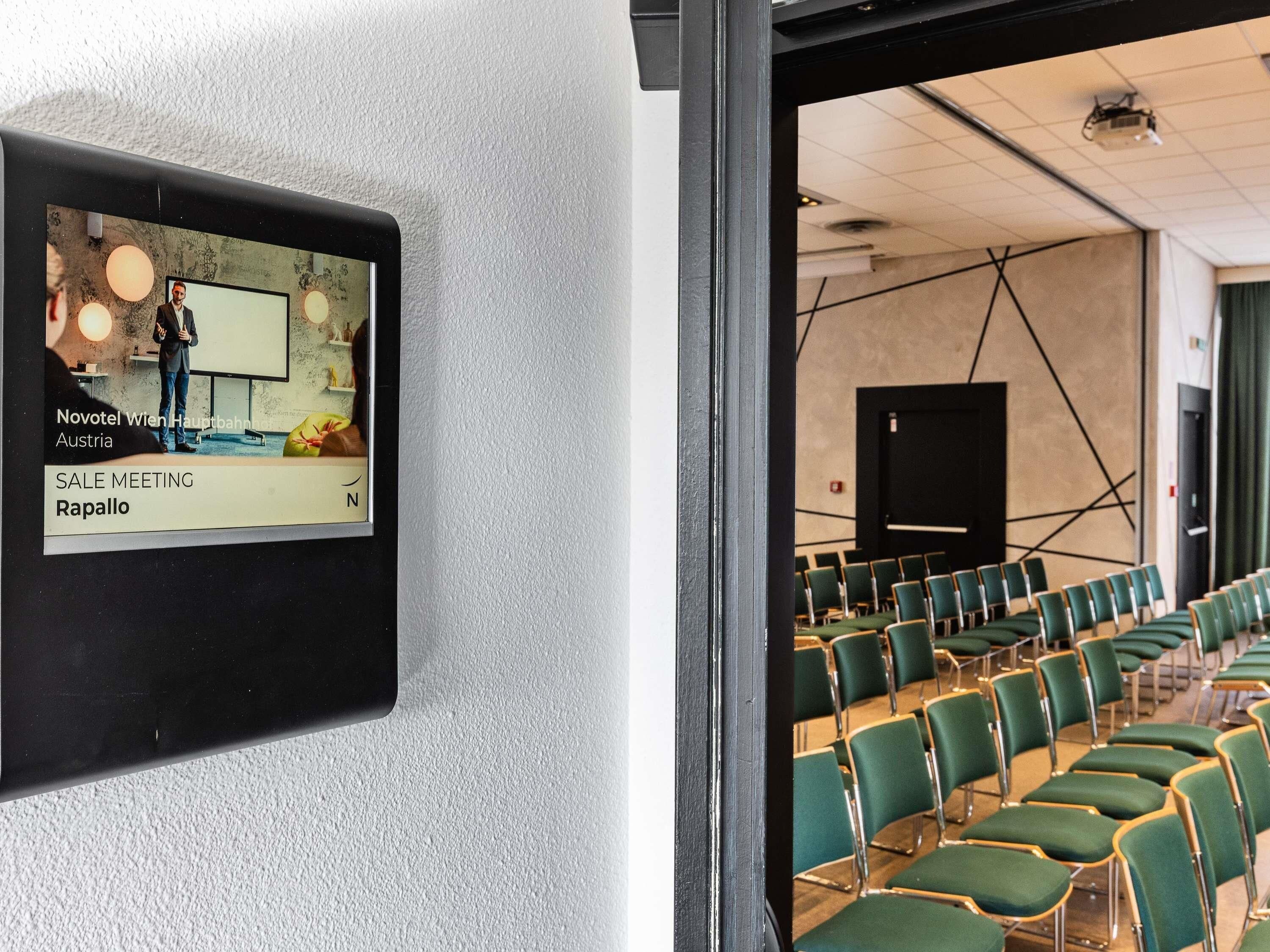 A conference room with green chairs and a whiteboard, indicating a meeting space.