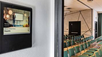 A conference room with green chairs and a whiteboard, indicating a meeting space.