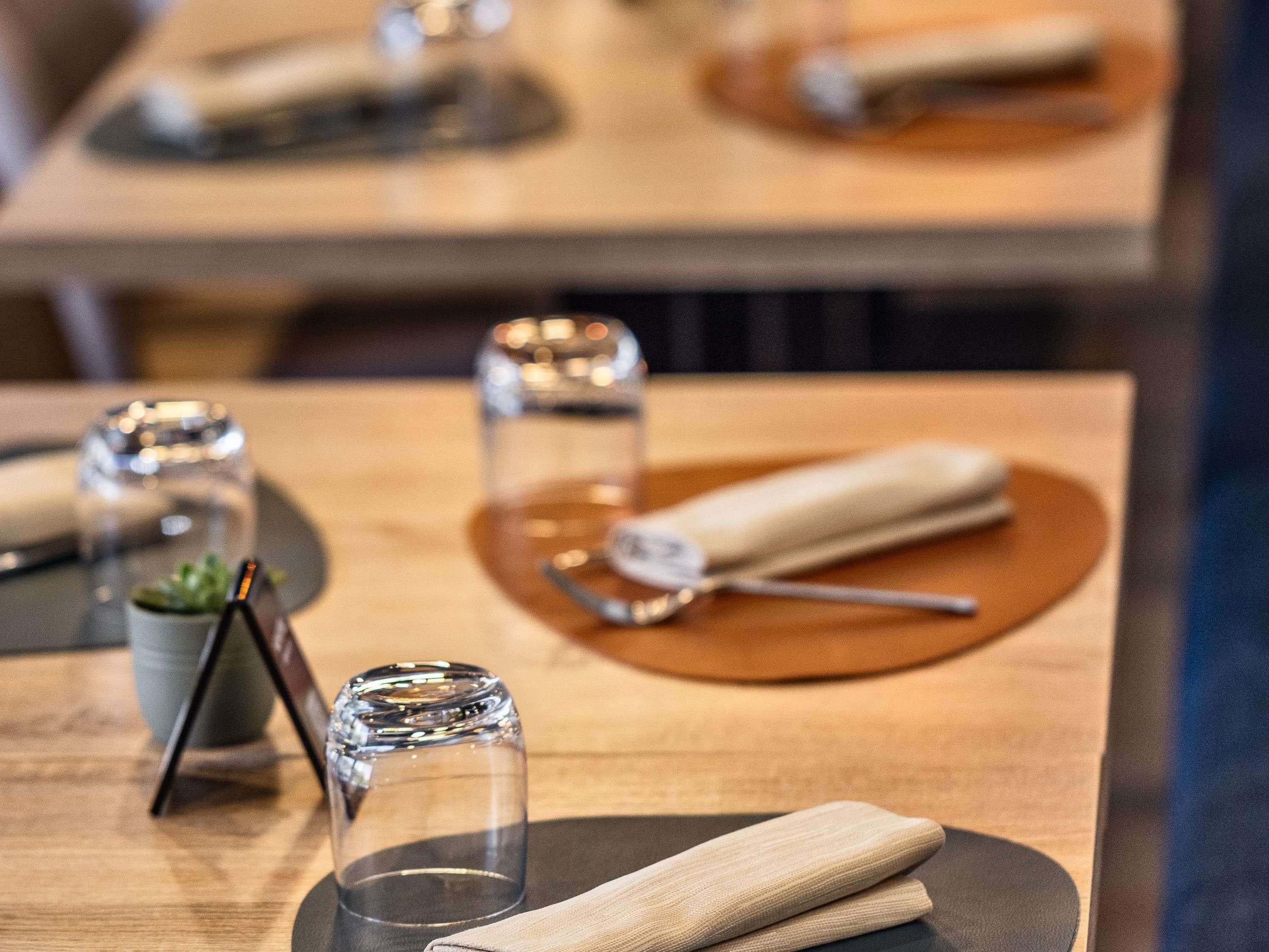Une table à manger avec une serviette, un verre et une petite plante en pot.