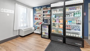 Une chambre d’hôtel équipée d’une kitchenette, d’un réfrigérateur rempli de boissons et d’en-cas, d’un four à micro-ondes et d’un petit téléviseur.
