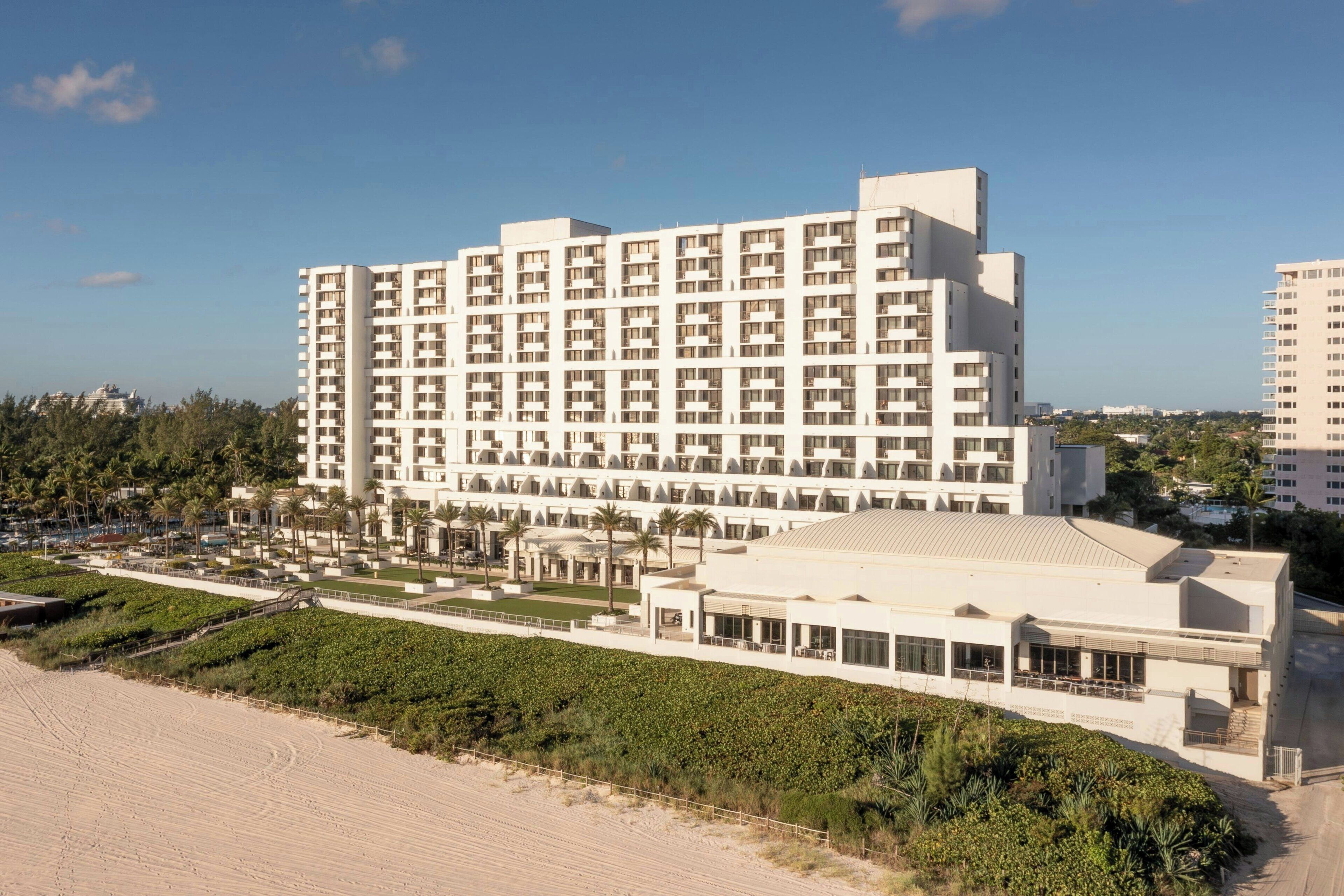 A large hotel with multiple floors, a beachside location, and a landscaped courtyard.