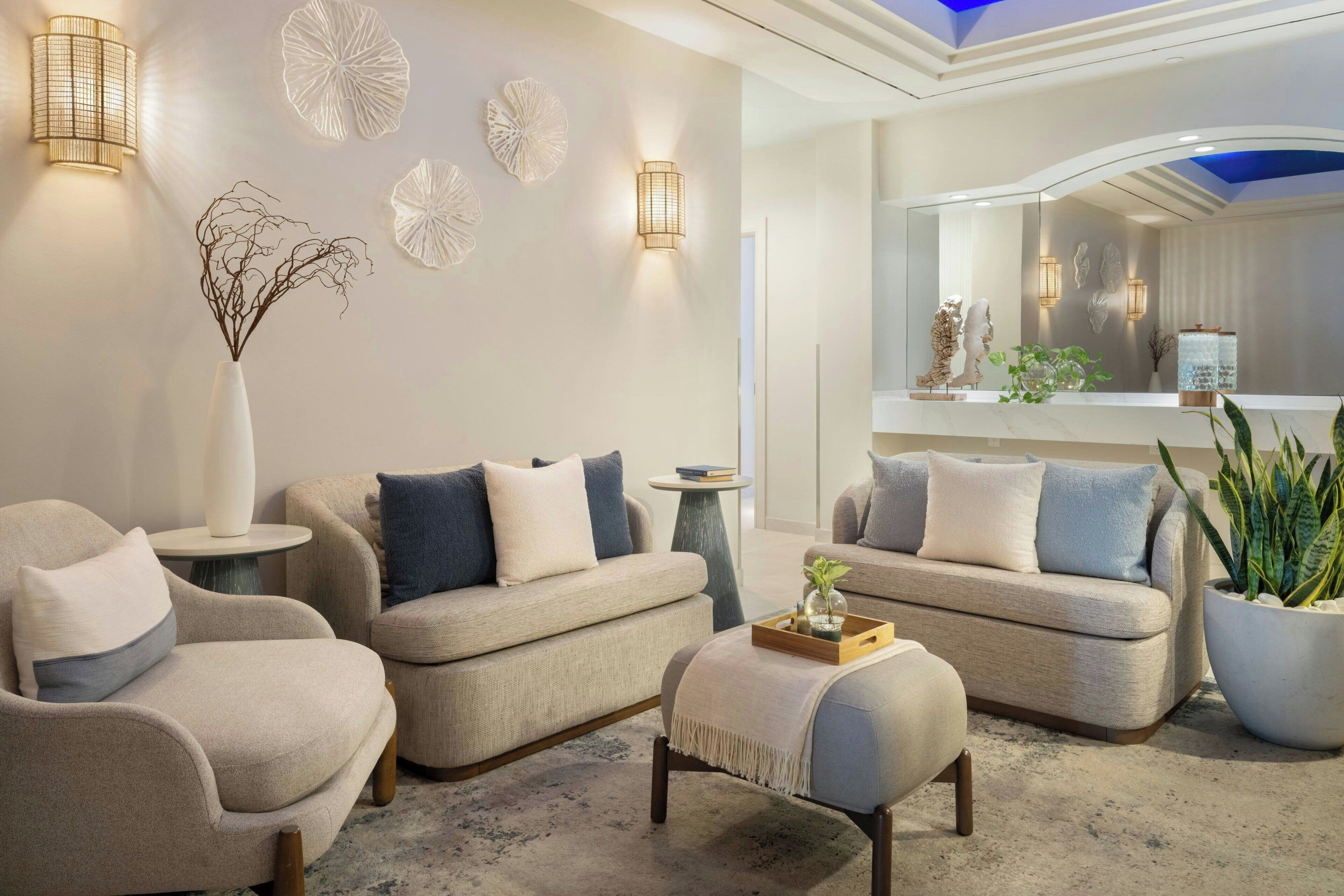 Ein modernes Wohnzimmer mit Sofas, einem Couchtisch, Wandbildern und Wandleuchten.