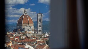 A historic building with a prominent dome and adjacent bell tower, surrounded by densely packed urban architecture. - Grand Hotel Adriatico (Florence)