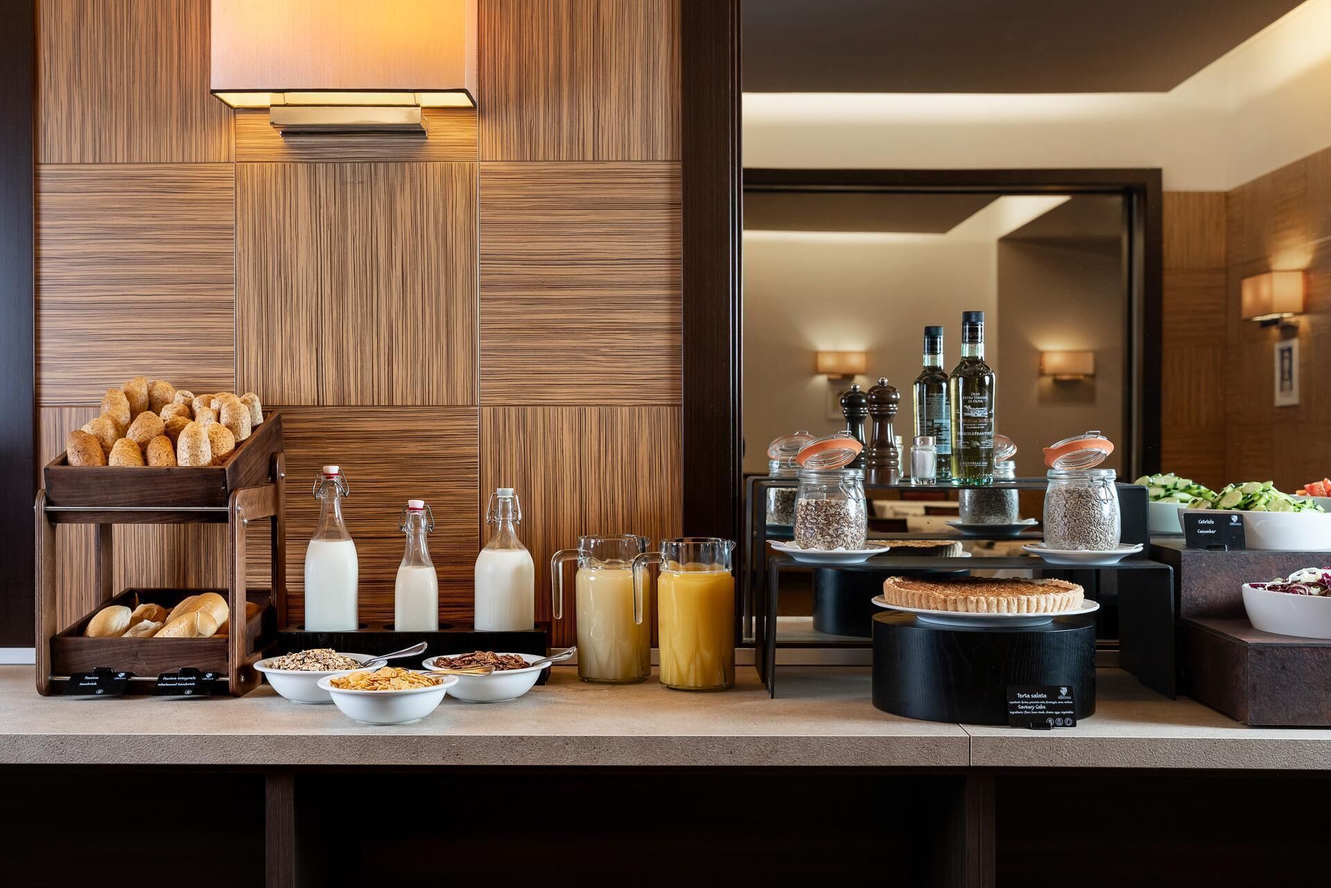A breakfast buffet with bread, cereals, milk, and juice.