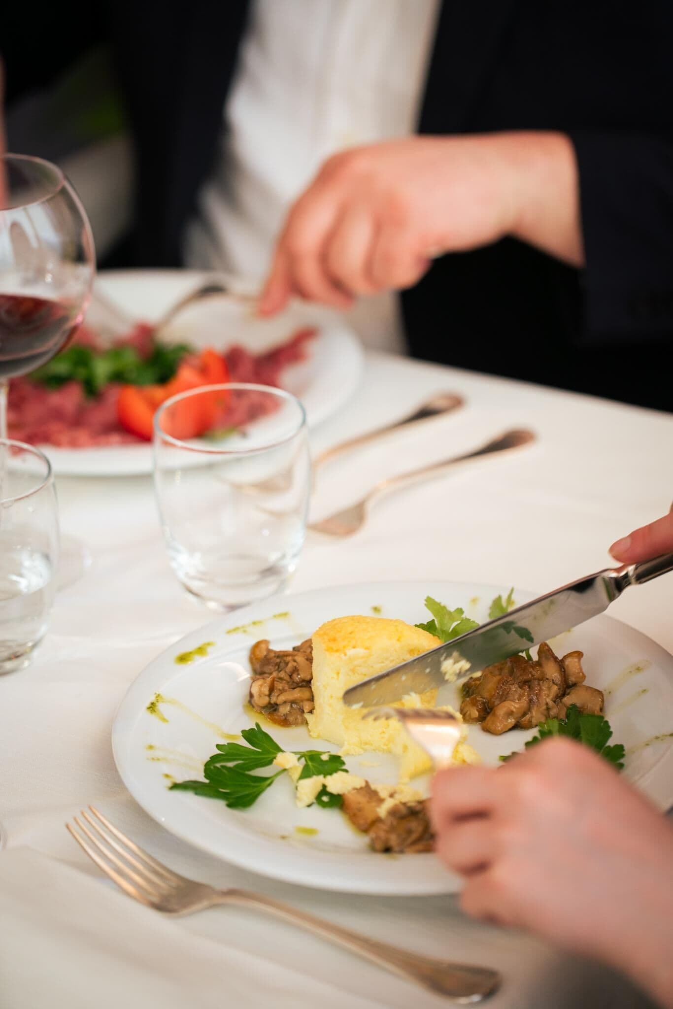 A dining table with a plate of food, a fork, and a knife.