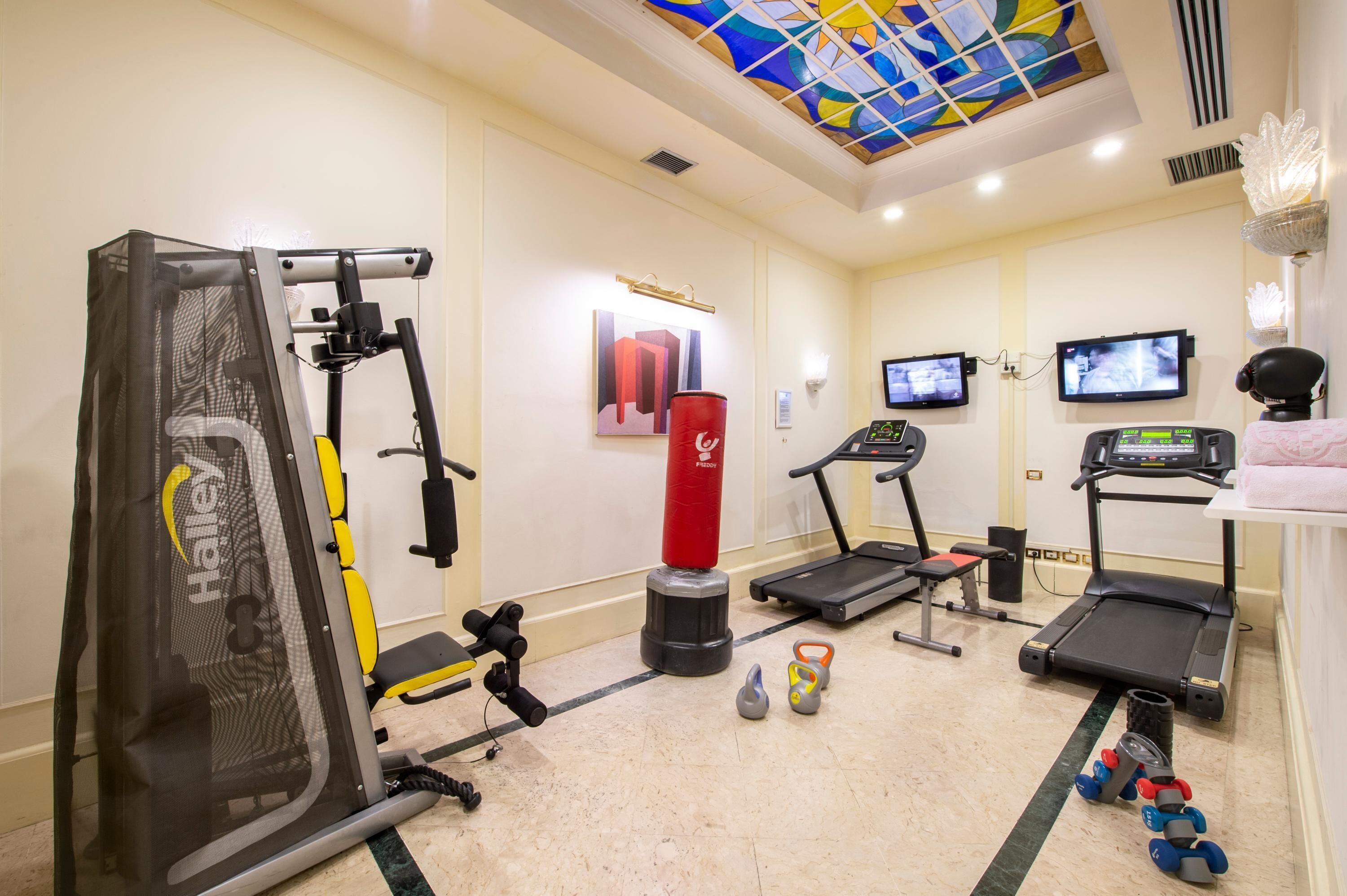 A gym with exercise equipment, treadmills, and weights.