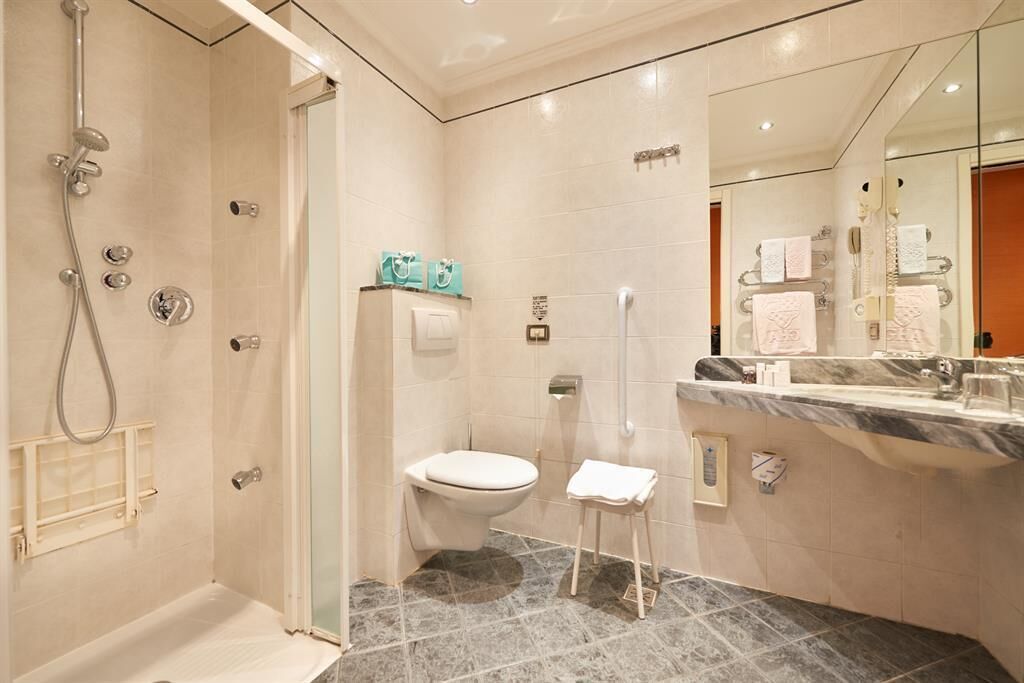 A modern bathroom with a shower, toilet, and vanity.