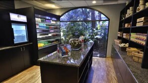 A modern bar area with a large aquarium, shelves stocked with beverages, and a wooden floor. - DoubleTree Suites by Hilton Hotel McAllen (McAllen)