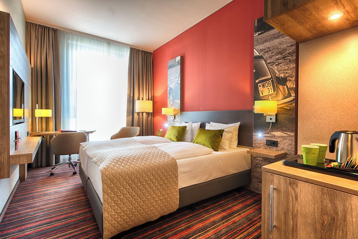 Une chambre d’hôtel comprenant un lit, un bureau et un coin salon.