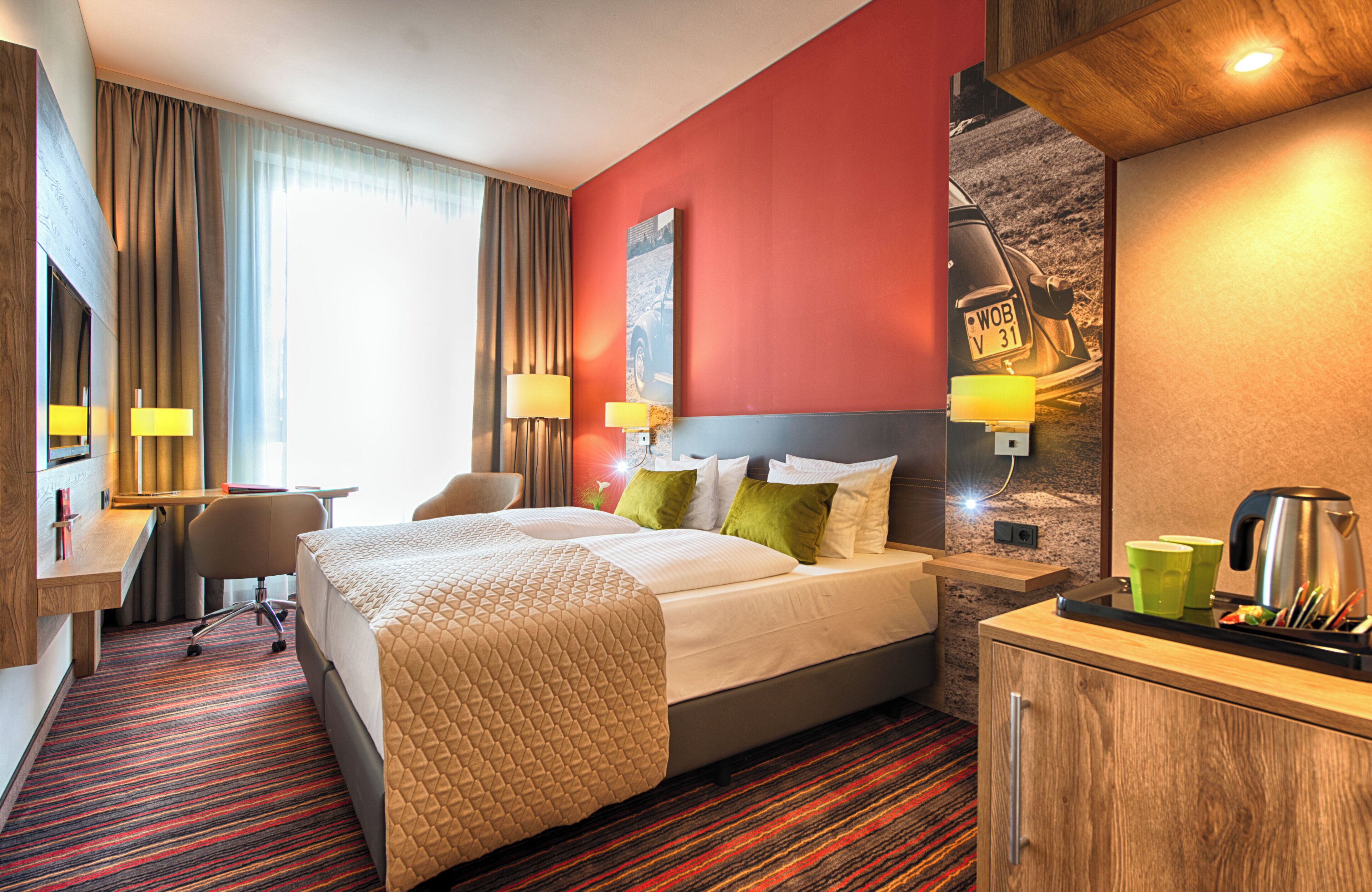 Une chambre d’hôtel comprenant un lit, un bureau et un coin salon.