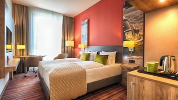 A hotel room with a bed, desk, and seating area.