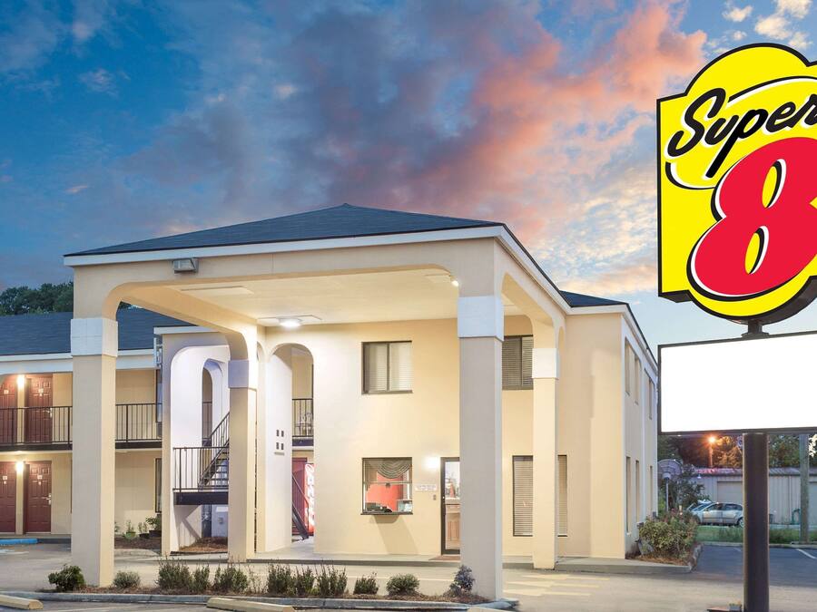 A hotel with a covered entrance, multiple balconies, and a Super 8 sign.